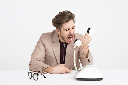 Uomo che urla al telefono, simbolo di tensioni e decisioni legate alla capacità di intendere e di volere.